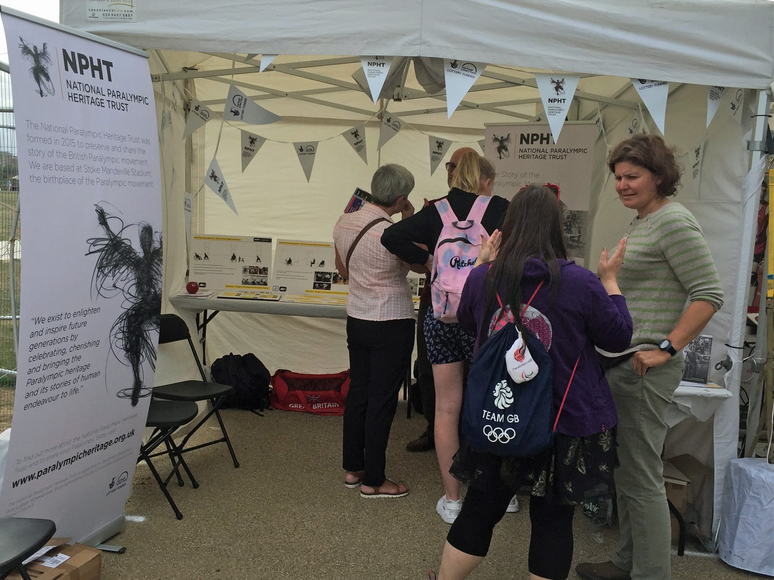 people standing talking, next to a pop up banner