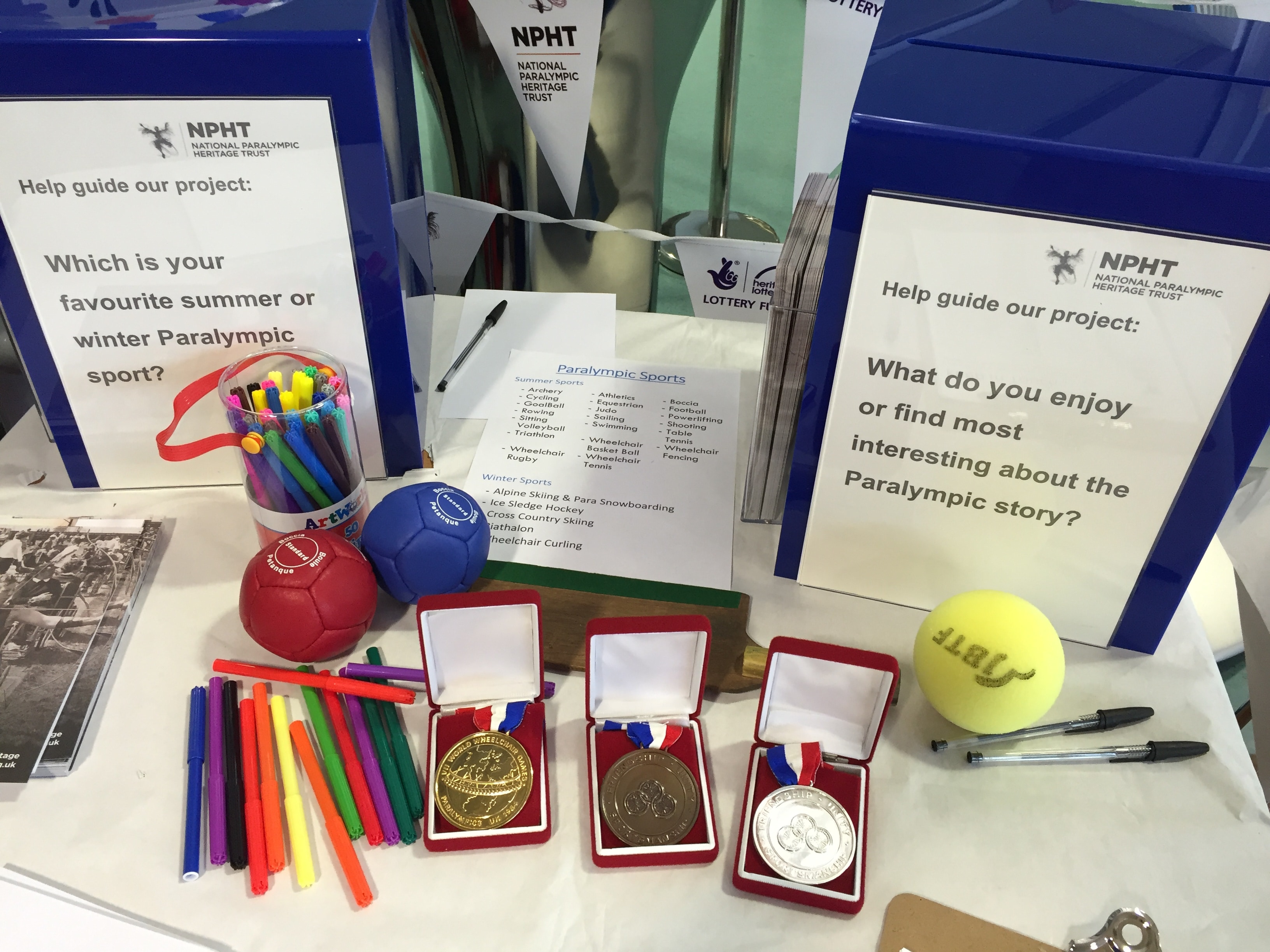Three paralympic medals and boxes with questions on.