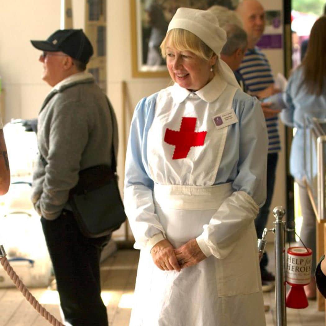 lady dressed in british red cross uniform.