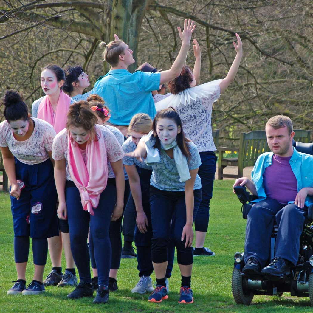 Young people aged 18- 25 years, in costume on grass performing contemporary dance.