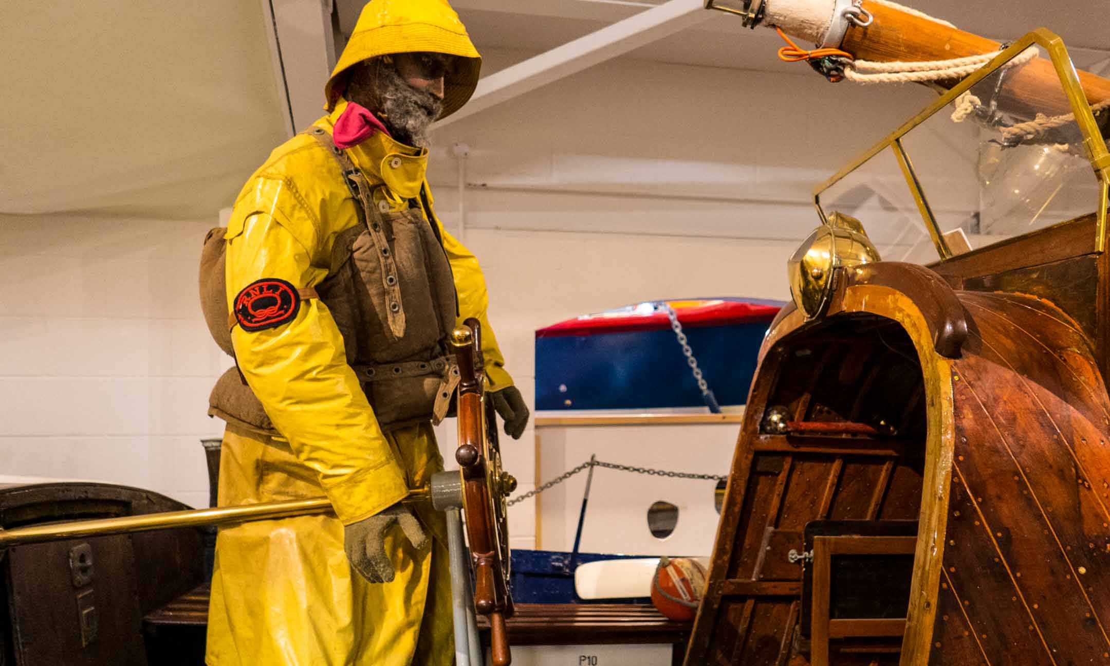 mannequin of man in full waterproofs, boat in foreground.