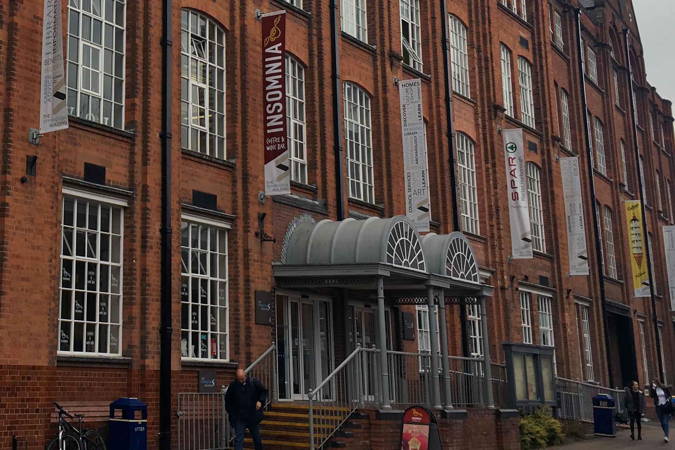 Red brick building with a canopy over a door. 