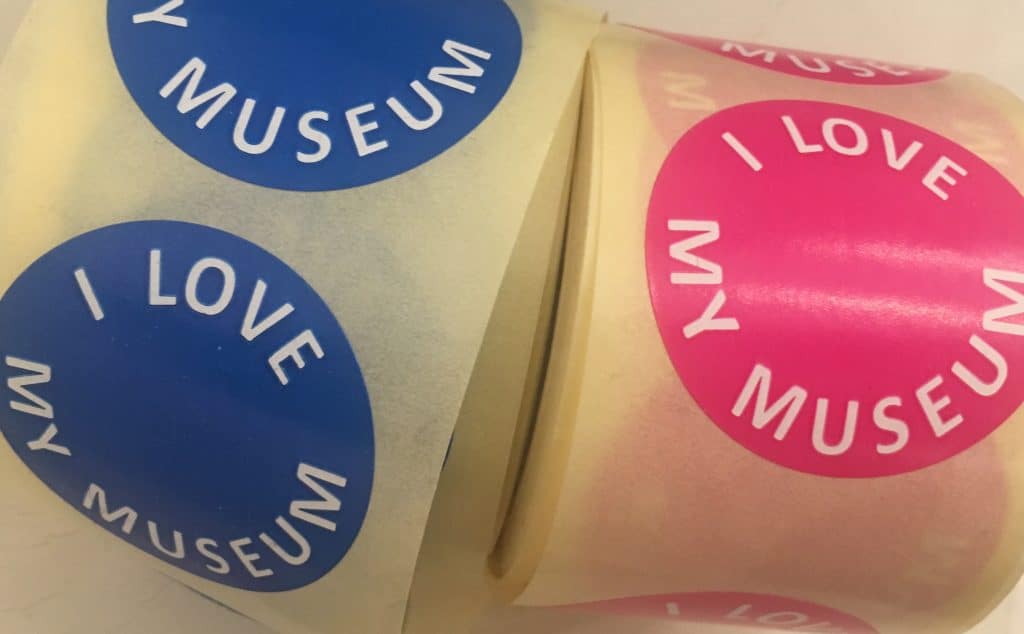 Two rolls of stickers, one blue, one pick, saying I Love my Museum.