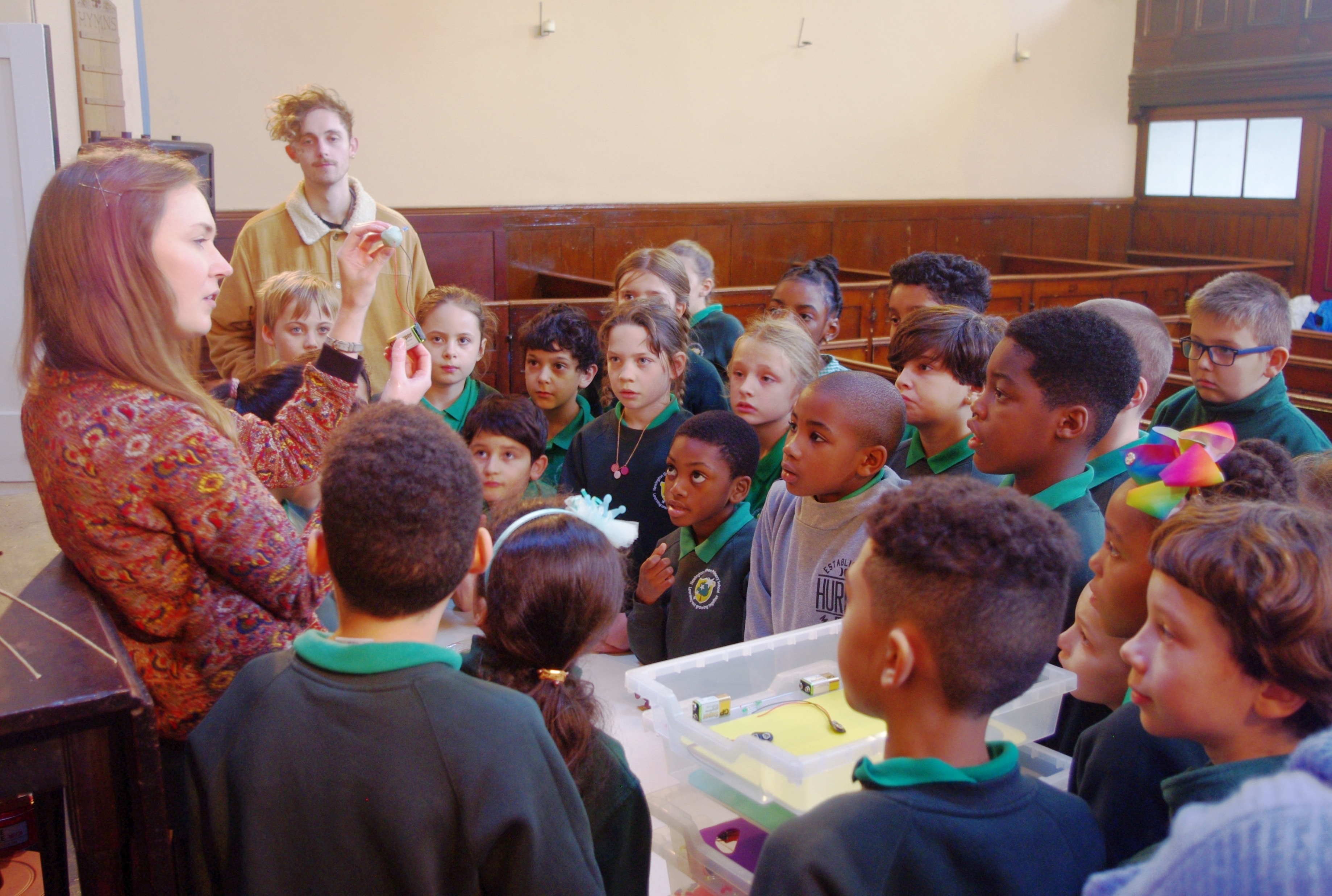 Woman talking to a group of school children.
