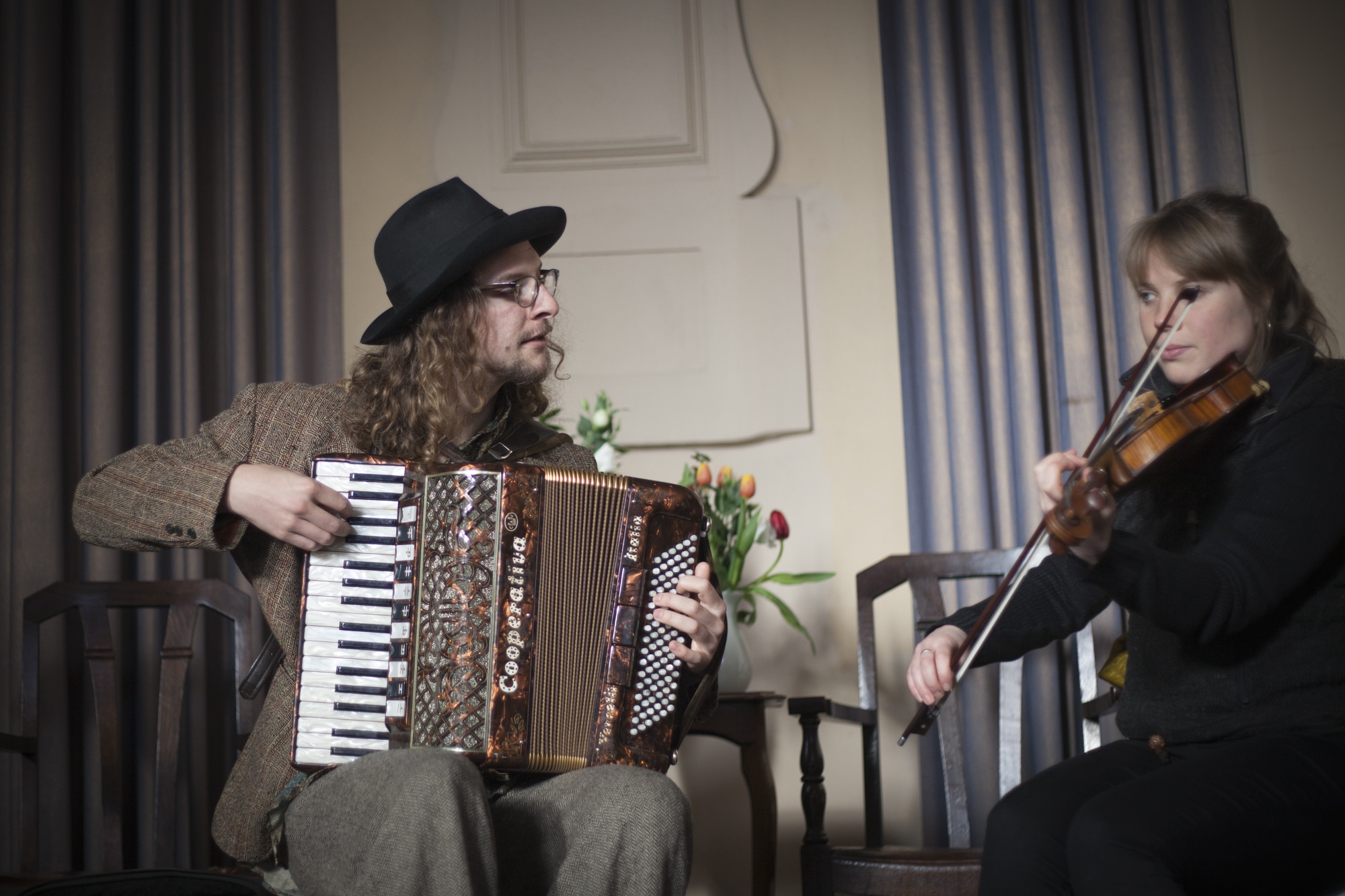 A man playing accordian and a woman playing the violin. 