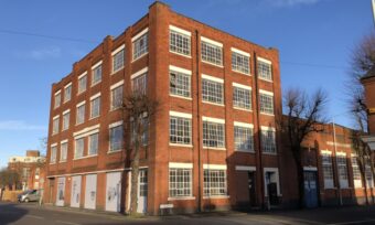 A square red-brick building set against a blue sky.